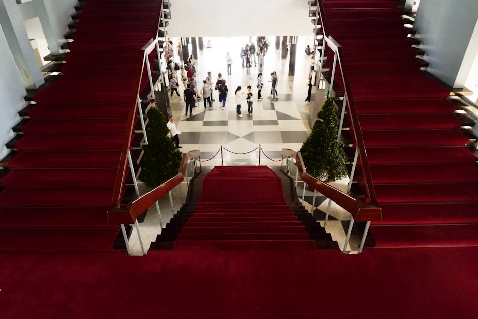 Elegant red-carpeted staircase inside a historic Vietnamese building.